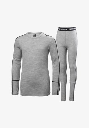 Conjunto de top térmico gris y leggings. El top tiene mangas largas, cuello redondo y detalles en negro; los leggings cuentan con una cinturilla elástica y rayas laterales.