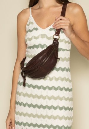 Hnědý kožený ledvinka s zakřiveným tvarem, dvěma zipovými kapsami a širokým nastavitelným popruhem nošeným přes tělo.