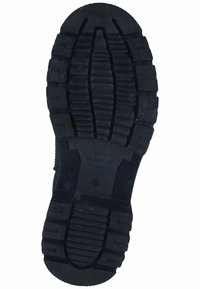 Semelle en caoutchouc noir avec de profondes rainures et crêtes pour l'adhérence. Présente un logo en relief et des marquages de taille sur la zone de l'arche.