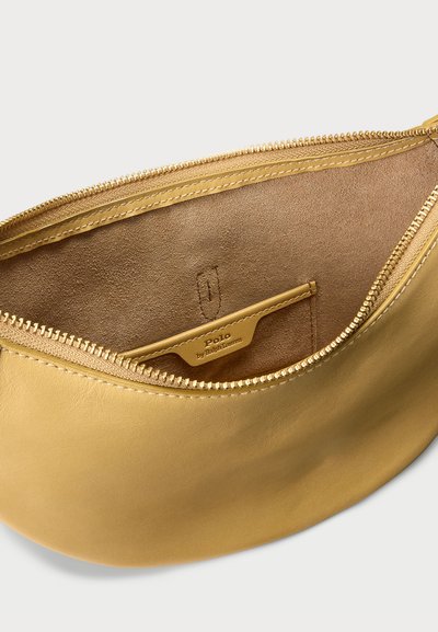 Rumena usnjena torbica z gladko teksturo, zadrgo in notranjim žepom, na katerem je vtisnjen logotip blagovne znamke.