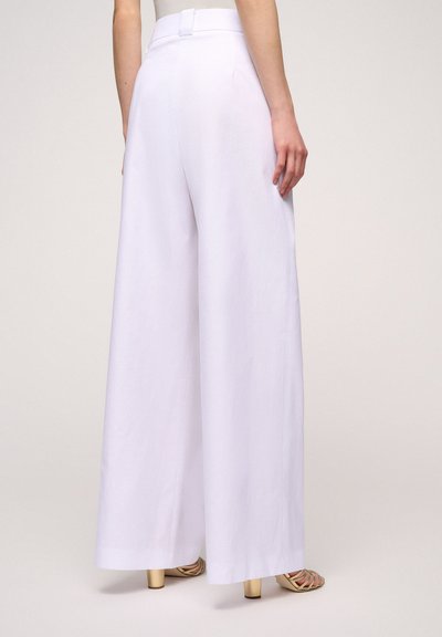 Witte wijde broek van lichtgewicht materiaal, met een hoge taille en een schone, gladde textuur. Achteraanzicht met zakken.