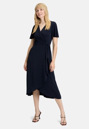 Wickelkleid aus navy Stoff mit kurzen, luftigen Ärmeln, V-Ausschnitt und asymmetrischem Saum. Glatte Textur, verstellbarer Bindegürtel an der Taille.