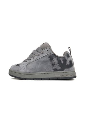 Niskie szare zamszowe sneakersy z ciemnoszarą podeszwą, wyściełanym kołnierzem, zapięciem na sznurówki i dużym czarnym logo DC z boku.