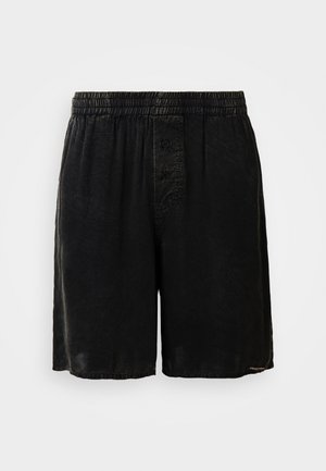 Shorts noirs avec une taille élastique, deux boutons à l'avant et un tissu texturé. Présente un ourlet au niveau du genou. Design minimaliste.