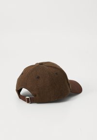 Braune Baseballmütze mit Fischgrätmuster, verstellbarem Riemen und Metallverschluss, von hinten auf weißem Hintergrund gezeigt.