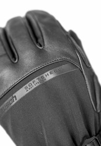 Black softshell gloves featuring a textured leather palm, reinforced seams, and a sleek design. Includes a label indicating 4-way stretch.