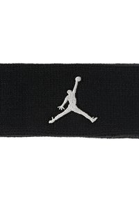Svart stoffstropp med elastisk tekstur, med en fremtredende sølv Jumpman-logo i en midt-hopp positur.