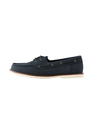 Scarpa da barca in pelle blu navy con suola bianca, chiusura frontale con lacci, cucitura moc toe e dettagli con occhielli laterali.