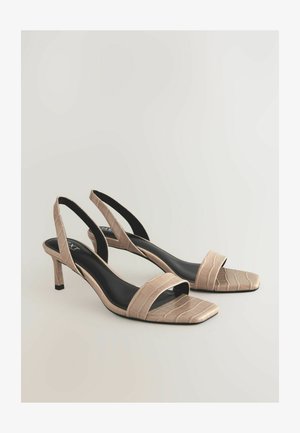 Beige színekben kapható slingback magassarkúk, krokodilbőr mintázattal, nyitott orral és karcsú sarkakkal; sima fekete talpbetét jellemzi.