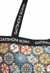 Correas de tela negra con el texto "Gattinoni Roma" en una bolsa de colores con un patrón que presenta motivos geométricos en azul, naranja y amarillo.