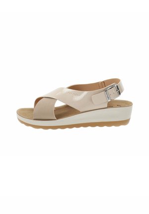 Sandal beige chiaro con cinturini incrociati, fibbia alla caviglia regolabile, soletta imbottita e una suola in platform bianca con fondo in gomma texturizzata.