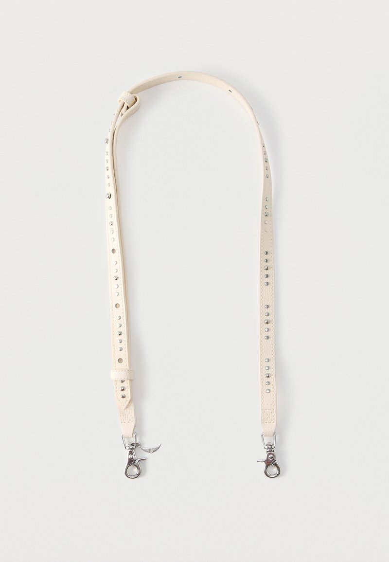 Ρυθμιζόμενο μπεζ δερμάτινο λουράκι με μεταλλικά κλιπ και διακοσμητικές μεταλλικές καρφίτσες σε απλό φωτεινό φόντο.