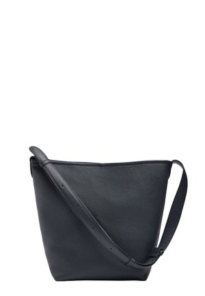 Czarna torebka na ramię ze skóry ziarnistej z regulowanym paskiem i minimalnym przeszyciem, w kształcie trapezu o szerokim wierzchu na białym tle.