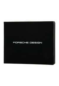 Scatola rettangolare nera con una superficie liscia, con "PORSCHE DESIGN" in rilievo di colore bianco, centrata sul frontale.
