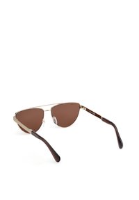 Gafas de sol aviador metálicas con lentes marrones. Montura delgada dorada, almohadillas nasales ajustables y puntas de templo de plástico marrón oscuro.