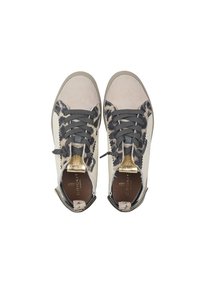 Sneakers met een combinatie van lichtbeige leer en zwarte dierenprintaccenten, met grijze veters en een gouden logo op de tong.