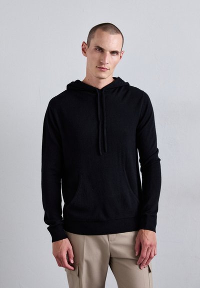 Sort hoodie med snor, frontlomme og ribbede manchetter og kant. Fremstillet af blødt materiale med en afslappet pasform og glat tekstur.