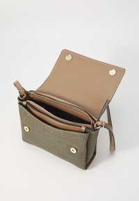Small crossbody bag with a textured olive fabric exterior and a tan leather interior, featuring a zippered pocket and gold hardware accents.