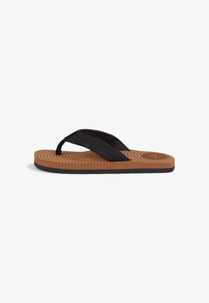 Schwarze Flip-Flop-Sandale mit Stoff-Zwischenräumen, strukturiertem braunem Fußbett und Gummisohle mit Wellenmustern für bessere Traktion.