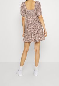 Kukkakuosiset mekot, joissa on lyhyet puffi-hihat, neliömäinen selkä ja kerroksellinen hame. Yhdistetty valkoisiin tennareihin ja nilkkasukkosiin.