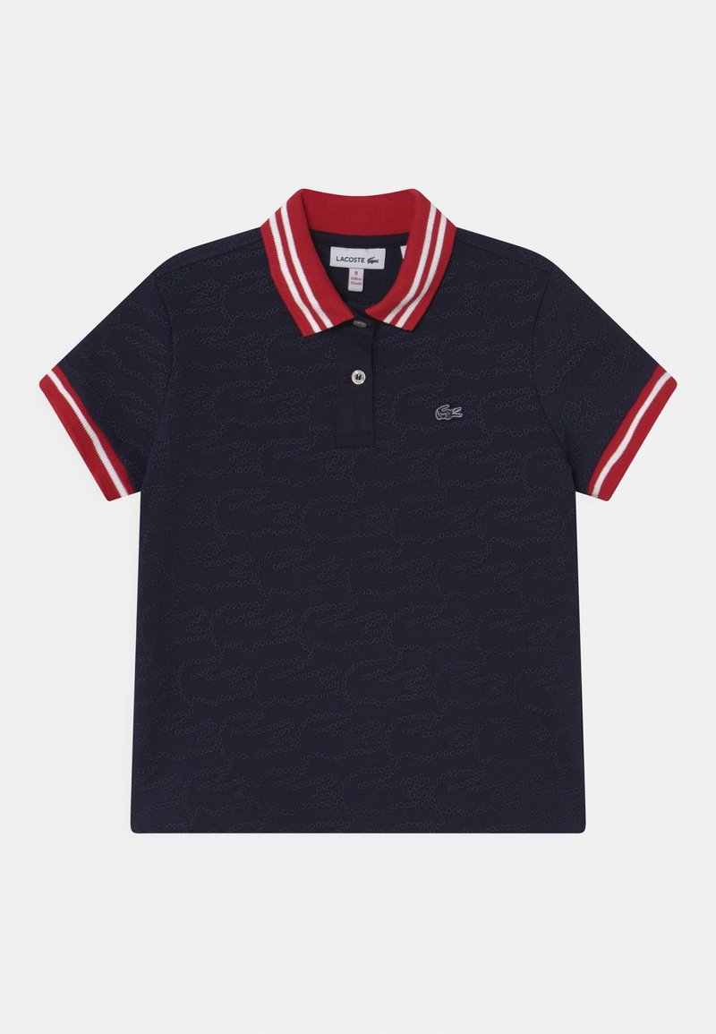 Polo bleu marine manches courtes, col et bords de manches rayés rouge et blanc, petit logo brodé sur la poitrine.