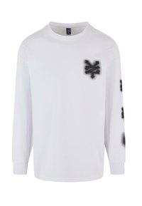 Long-sleeve white T-shirt made of cotton, featuring black spray paint-style graphics on the left chest and sleeve. Classic crew neck design.