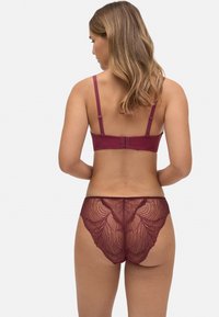 Conjunto de lencería de encaje burdeos que incluye un sujetador sin aros con textura y tirantes finos, acompañado de unas bragas de encaje con un intrincado detalle de patrones.