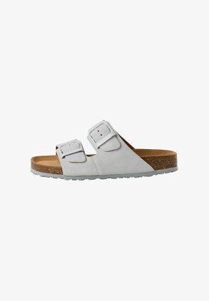 Weiße Wildleder-Slipper-Sandalen mit zwei verstellbaren Schnallen, einem Korkfußbett und einer strukturierten Gummisohle.