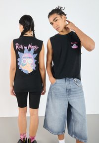 Schwarze ärmellose T-Shirts mit "Rick and Morty" Grafiken auf der Vorder- und Rückseite, kombiniert mit schwarzen Leggings und hellblauen Denim-Shorts.