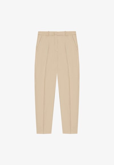 Pantalons beiges à coupe ajustée, présentant un devant plat, des passants de ceinture et des poches latérales. Tissu lisse avec un design net et épuré.