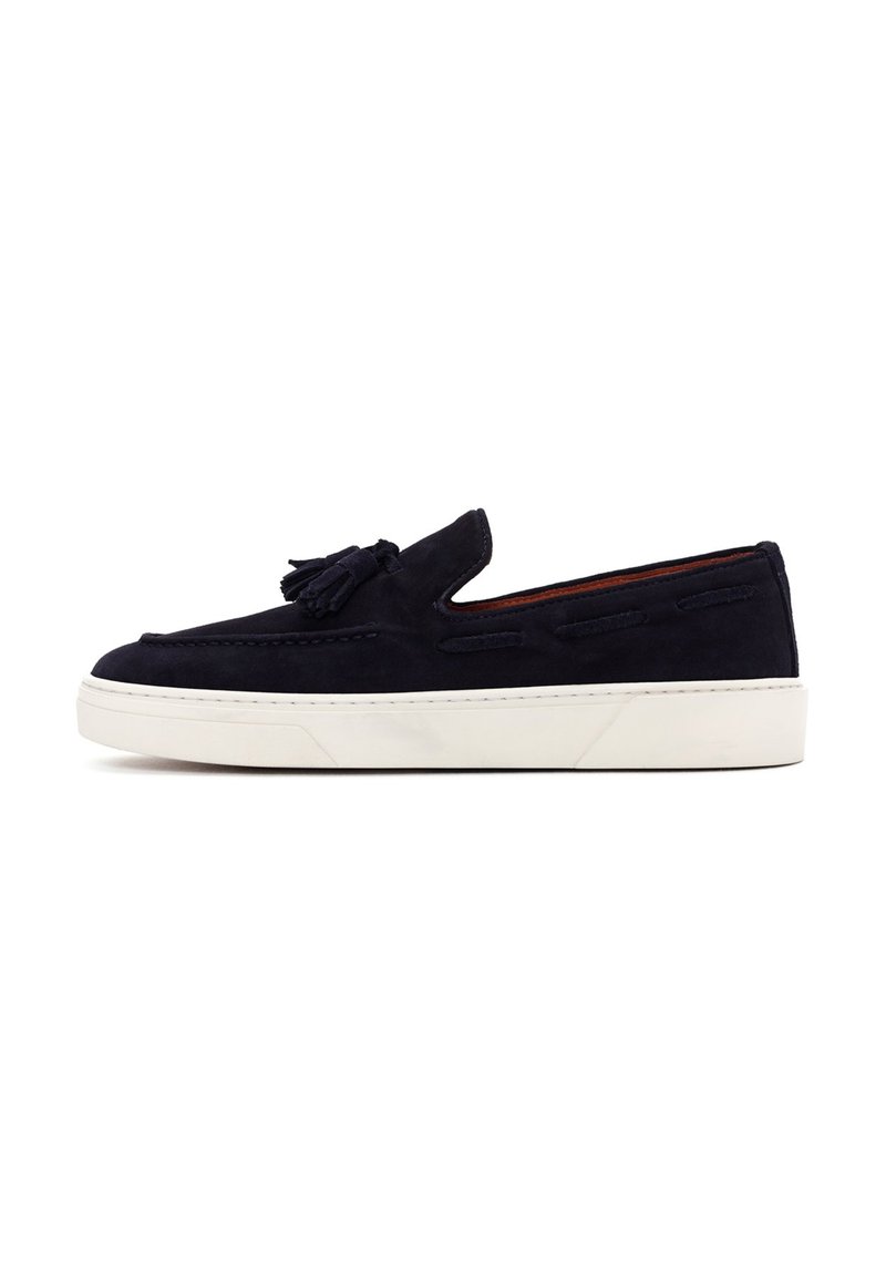 Navyblaue Wildlederschlupfschuhe verfügen über eine abgerundete Spitze, dekorative Quasten und eine weiße Gummisohle mit seitlichen Nähten und Ausschnitten.