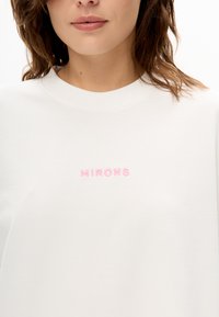 Weißes Sweatshirt mit Rundhalsausschnitt und rosa gesticktem Schriftzug "MIRONS" auf der Brust, hergestellt aus weichem Stoff mit glatter Textur.