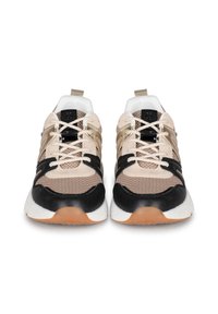 Baskets beige et noires en mesh et en cuir. Semelle intermédiaire blanche, semelle extérieure en caoutchouc style gomme, et accents métalliques contrastants sur les côtés.