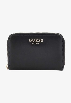 Portefeuille noir en cuir lisse avec fermeture éclair. Présente un logo "GUESS EST 1981" en ton or à l'avant. Design minimaliste.