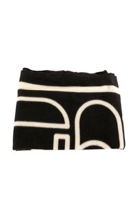 Coperta in pile bianca e nera piegata, caratterizzata da un audace design geometrico con una consistenza morbida e colori a contrasto.