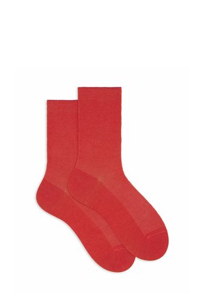 Calzini rossi in cotone con una texture a coste, lunghezza fino al polpaccio e punta senza cuciture. Presentano un colore uniforme senza motivi o dettagli.