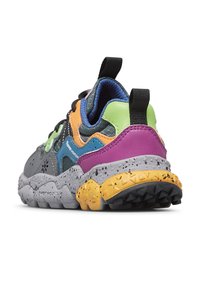 Zapatilla multicolor con un upper gris y acentos en azul, naranja, verde y morado, suela texturizada y una media suela amarilla moteada.