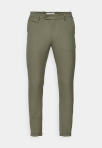 Olivgröna byxor med smal passform, slät front, en knappstängning och uppvikta fickor, tillverkade av ett mjukt material med minimal textur.