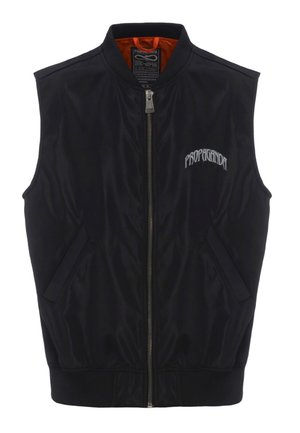 Gilet bomber nero con chiusura a zip, due tasche laterali e orlo a coste. L'interno presenta una fodera arancione. Logo "PROPAGANDA" ricamato in bianco.