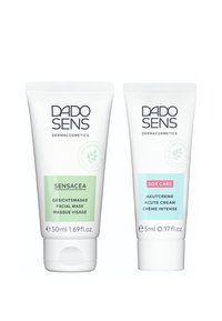 Two tubes of DADO SENS skincare products: a green 50ml facial mask and a blue 5ml acute cream, both with white caps and text.