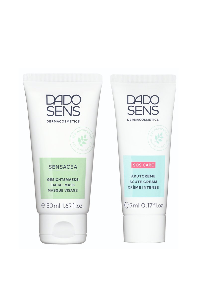 Two tubes of DADO SENS skincare products: a green 50ml facial mask and a blue 5ml acute cream, both with white caps and text.