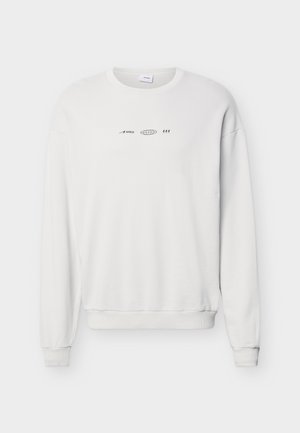 Balta crewneck tipo džemperis su mažais juodais logotipais ir simboliais krūtinės centre, su ribotu rankogalių ir apačios briaunomis.
