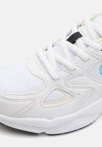 Hvite sneakers laget av mesh og lærmaterialer, med teksturerte mønstre, sort snørebåndholder og akvafargede detaljer for ekstra finesse.