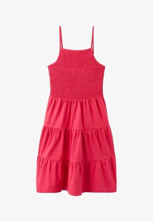 Robe rose sans manches avec un corsage smocké, une jupe à volants et un tissu en coton doux. Le design présente un haut cintré et un bas fluide.