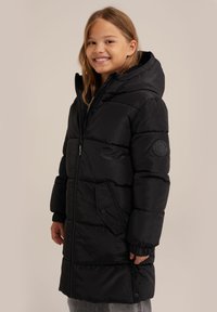 Černý péřový kabát s kapucí, vybavený předním zipem, kapsami na druk, žebrovanými manžetami a kulatým logem na rukávu.