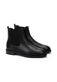 Botas Chelsea de cuero negro con paneles laterales elásticos, puntera redonda, costuras mínimas y suela de goma plana. Adecuadas para uso casual o formal.