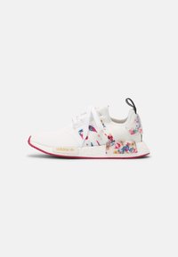 White Adidas sneakers with colorful floral accents, mesh upper, textured sole, pink rubber outsole, and gold logo on the side.