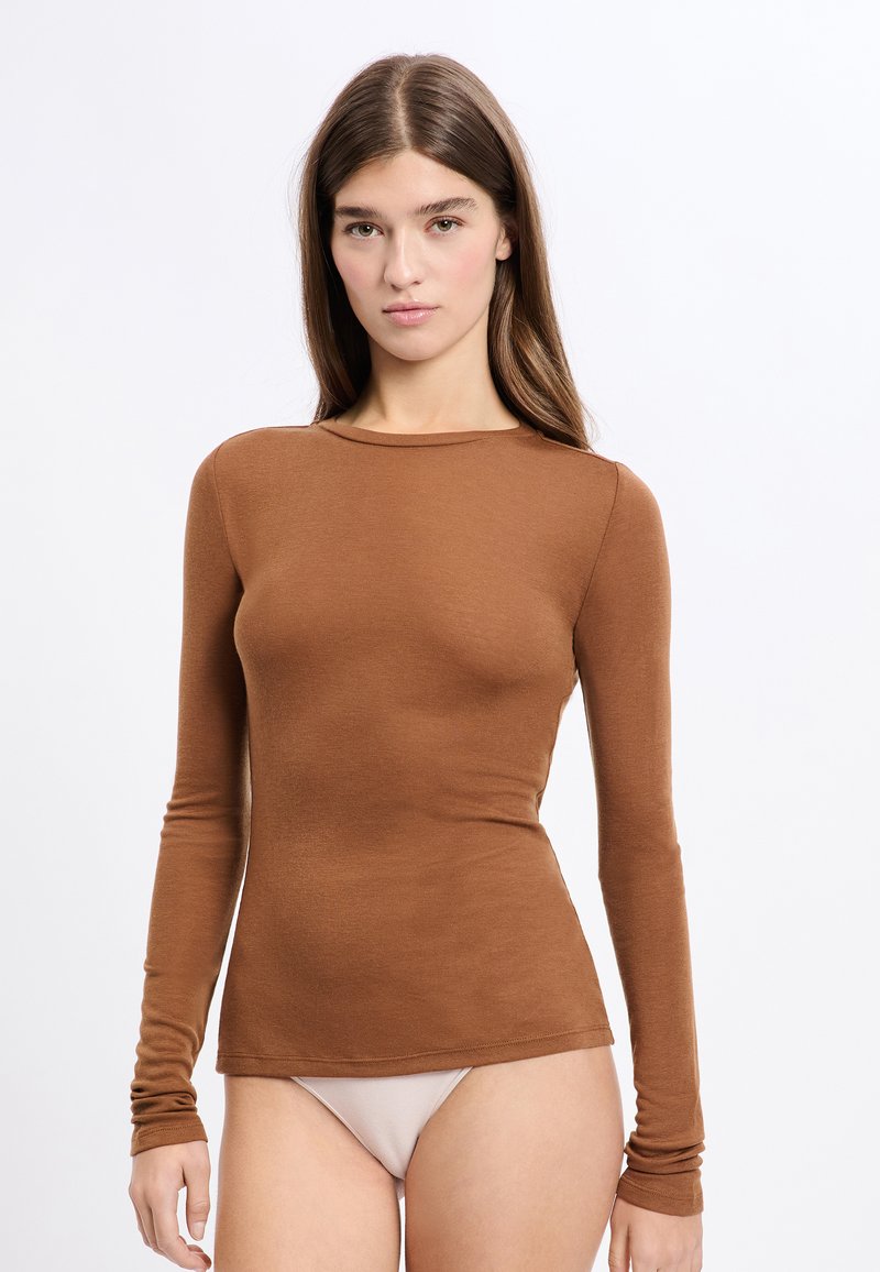Haut ajusté à manches longues dans une riche couleur marron, fabriqué en tissu doux et texturé. Il présente un col rond et des manches fines.