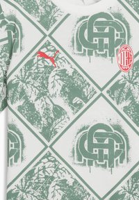 White T-shirt with green and gray graphic pattern featuring leaves and logos, red Puma emblem, and circular AC Milan badge.