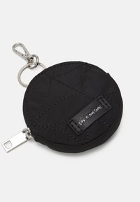 Schwarzes, rundes Täschchen aus gestepptem Stoff mit weißen Nähten. Verfügt über einen Reißverschluss und ein Gummitagschild mit der Aufschrift "LIFE IS AWESOME." Enthält einen Metallclip.